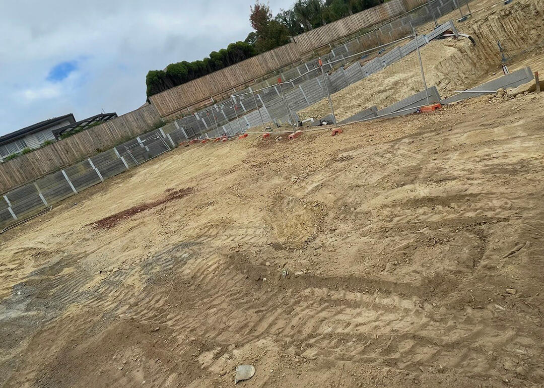 Melbourne site excavation with heavy machinery, preparing level ground for construction and building foundations.
