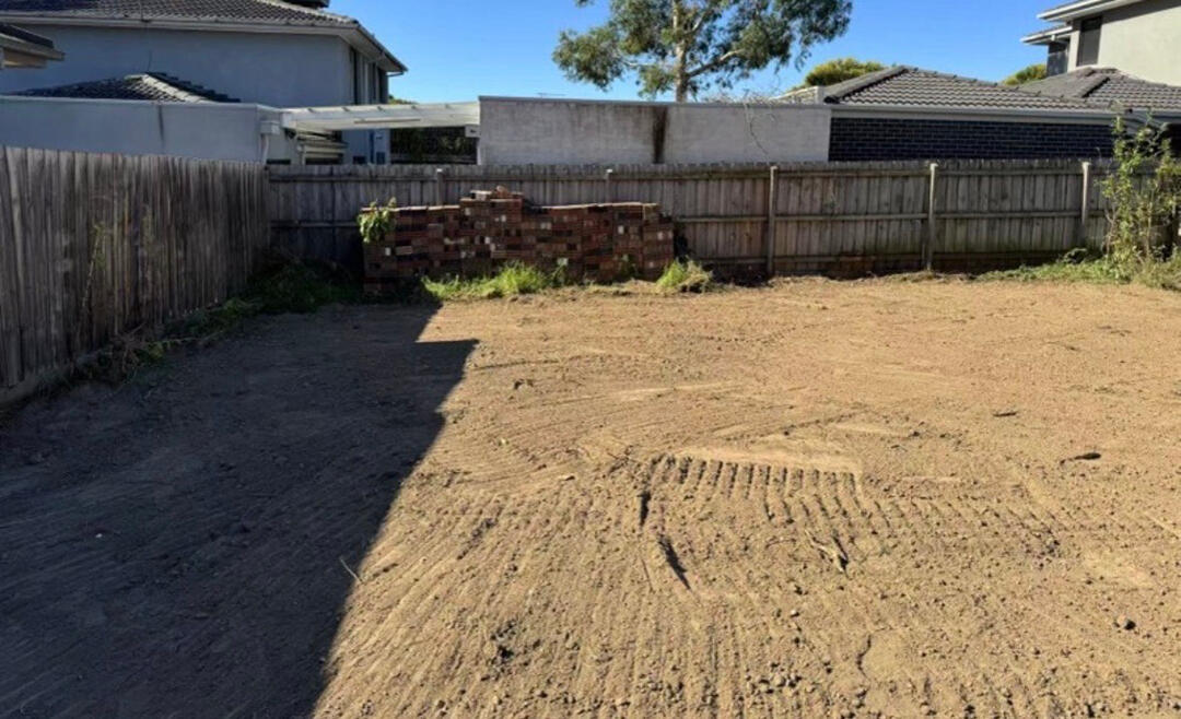 Excavator performing precise site cuts in Melbourne, flattening ground for residential and commercial construction projects.